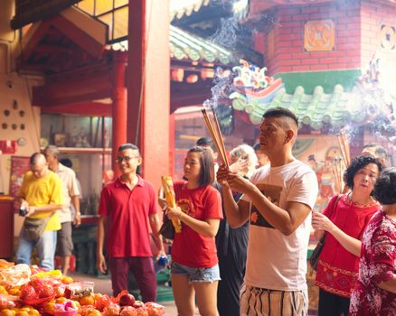 People engaging in spiritual practices at a vibrant temple in Kuala Lumpur, Malaysia.