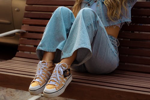 A Person in Denim Jeans Wearing White and Yellow Sneakers