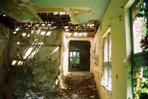 Free Sunlight filters through the broken roof of a decaying, abandoned house interior. Stock Photo