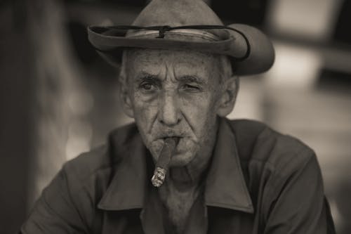 A Grayscale of a Man Smoking a Cigar