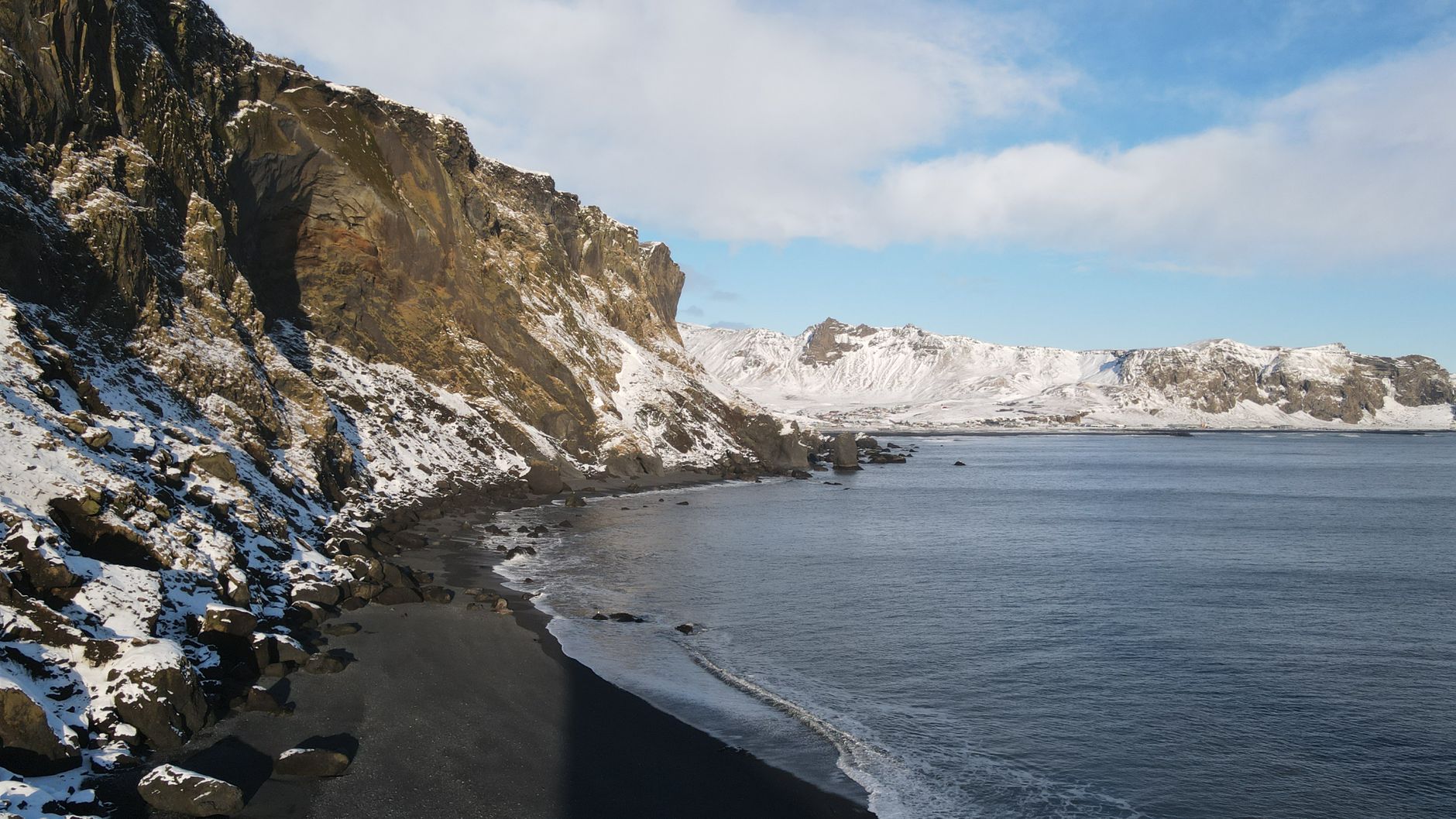 Vik church on the hill above the village and black beach beyond
