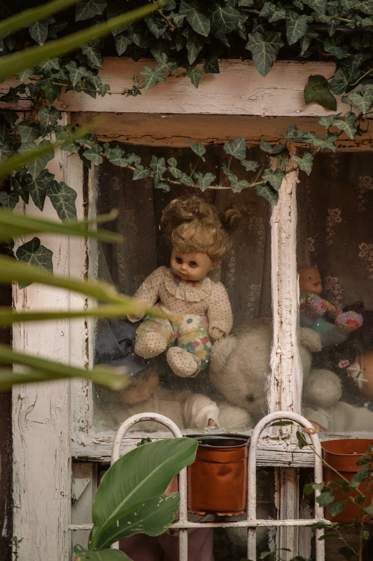 Abandoned Dolls On White Wooden Doll House