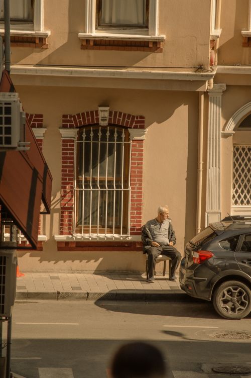 Free A senior man sits alone on a street in Arnavutköy, Istanbul, Turkey, capturing everyday life. Stock Photo