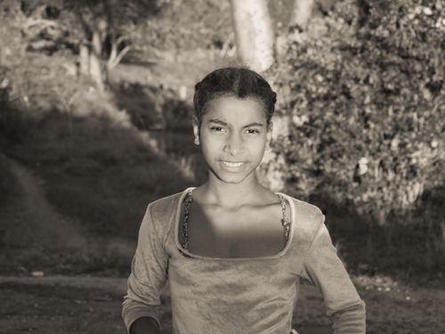 Free Grayscale portrait of a young girl smiling in a park setting. Stock Photo