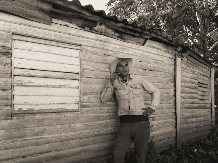 Cowboy Holding A Cigarette Leaning On A Wall