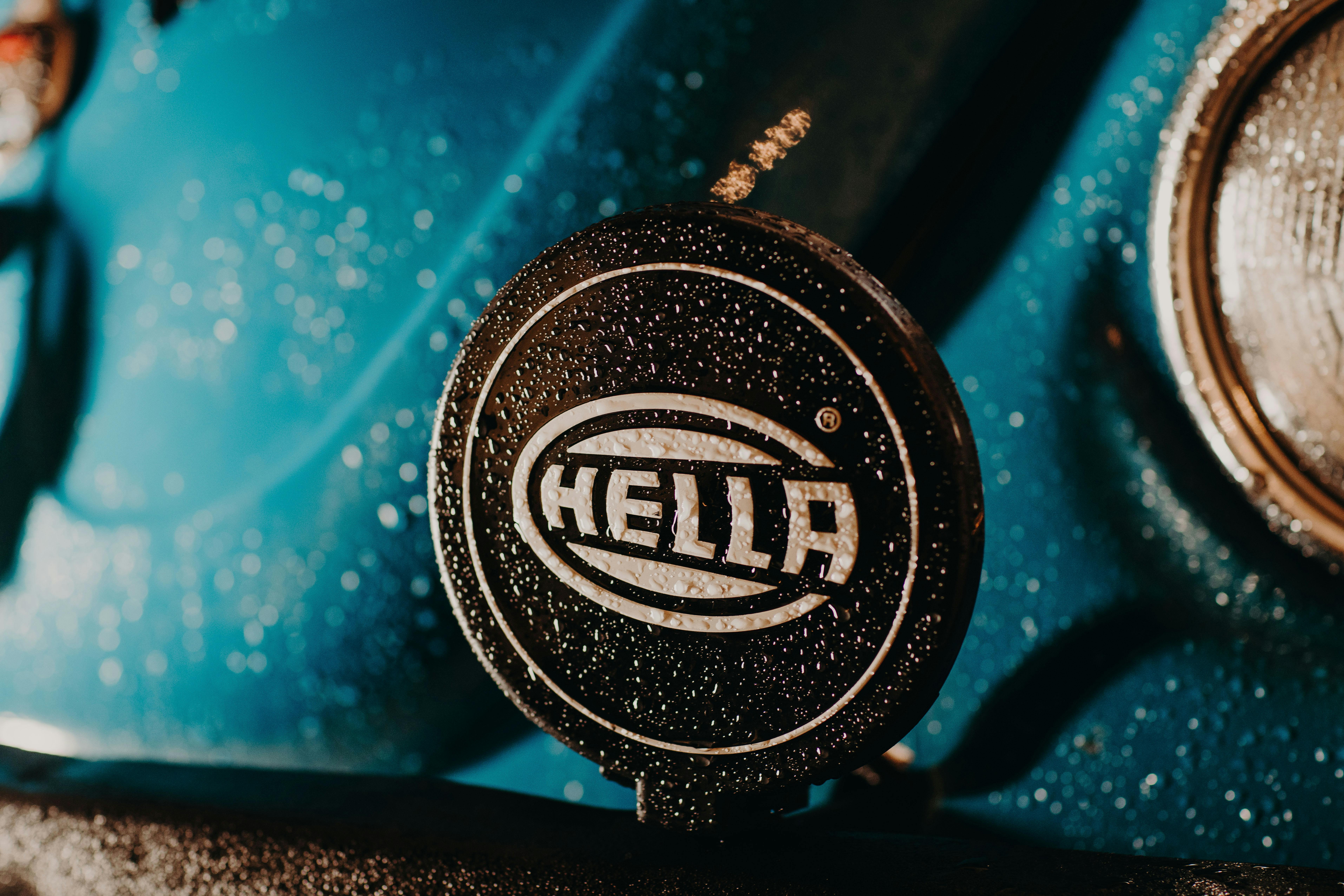 close up of wet emblem of hella company on a car