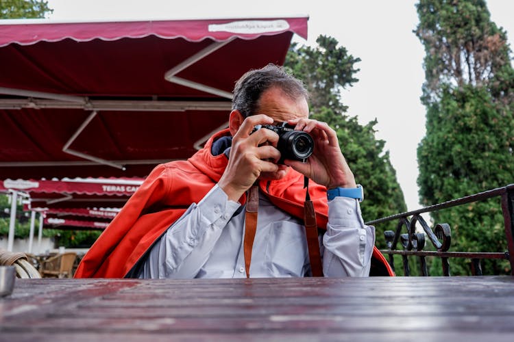 A Man Using A Black Camera