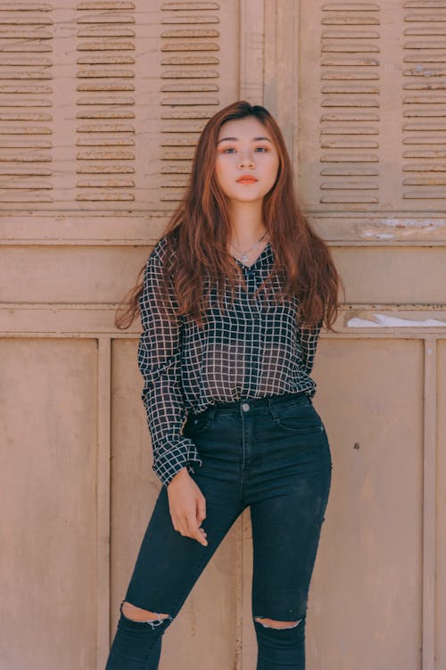 Woman Standing Near Brown Wall