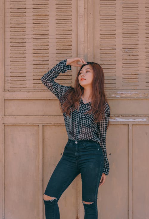 Woman Standing Near Brown Wall