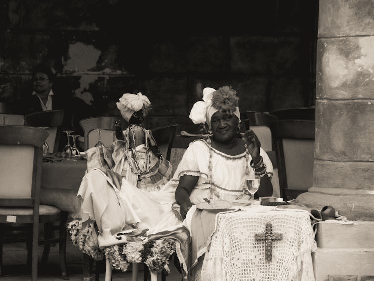 Woman Sitting With A Marionette At A Restaurant Table