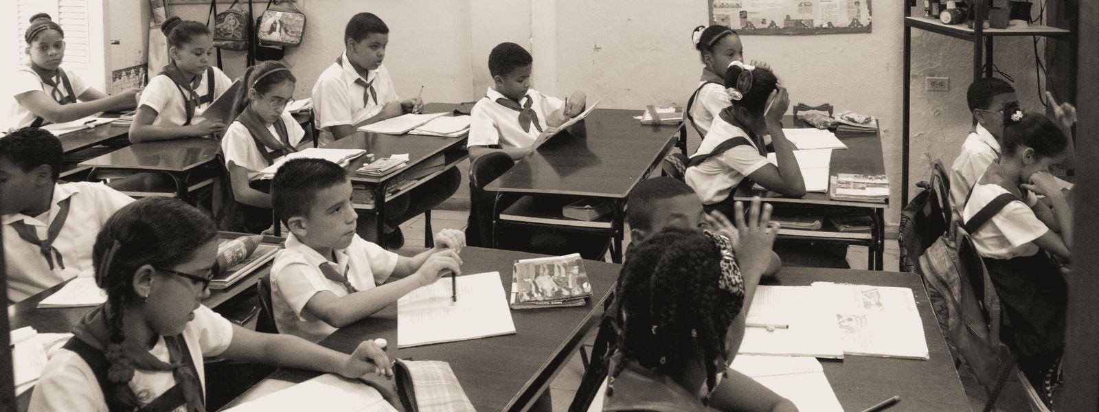 A classroom of attentive school children studying at their desks in uniform.
