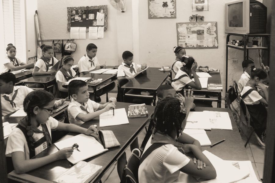 A primary classroom with low tables and children's work on the walls