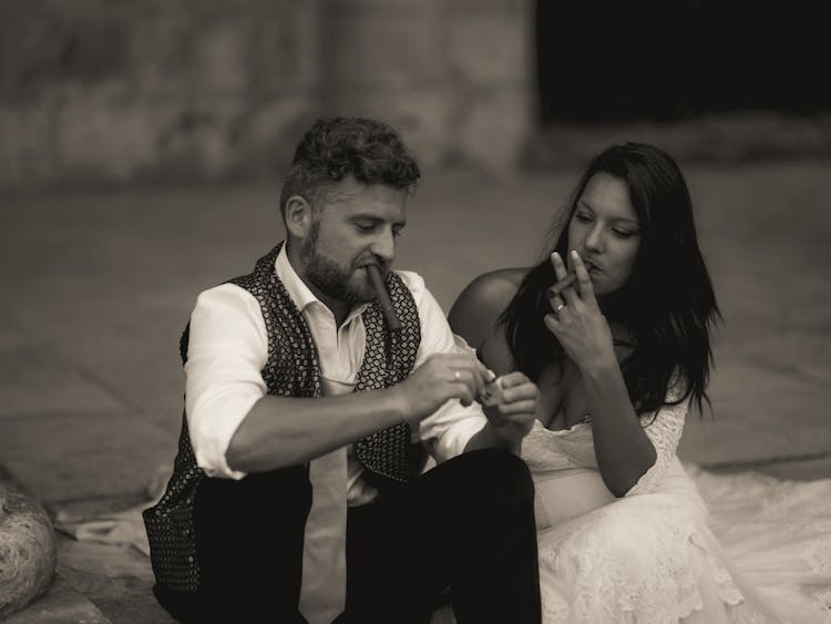 A Man And A Woman Smoking Cigars