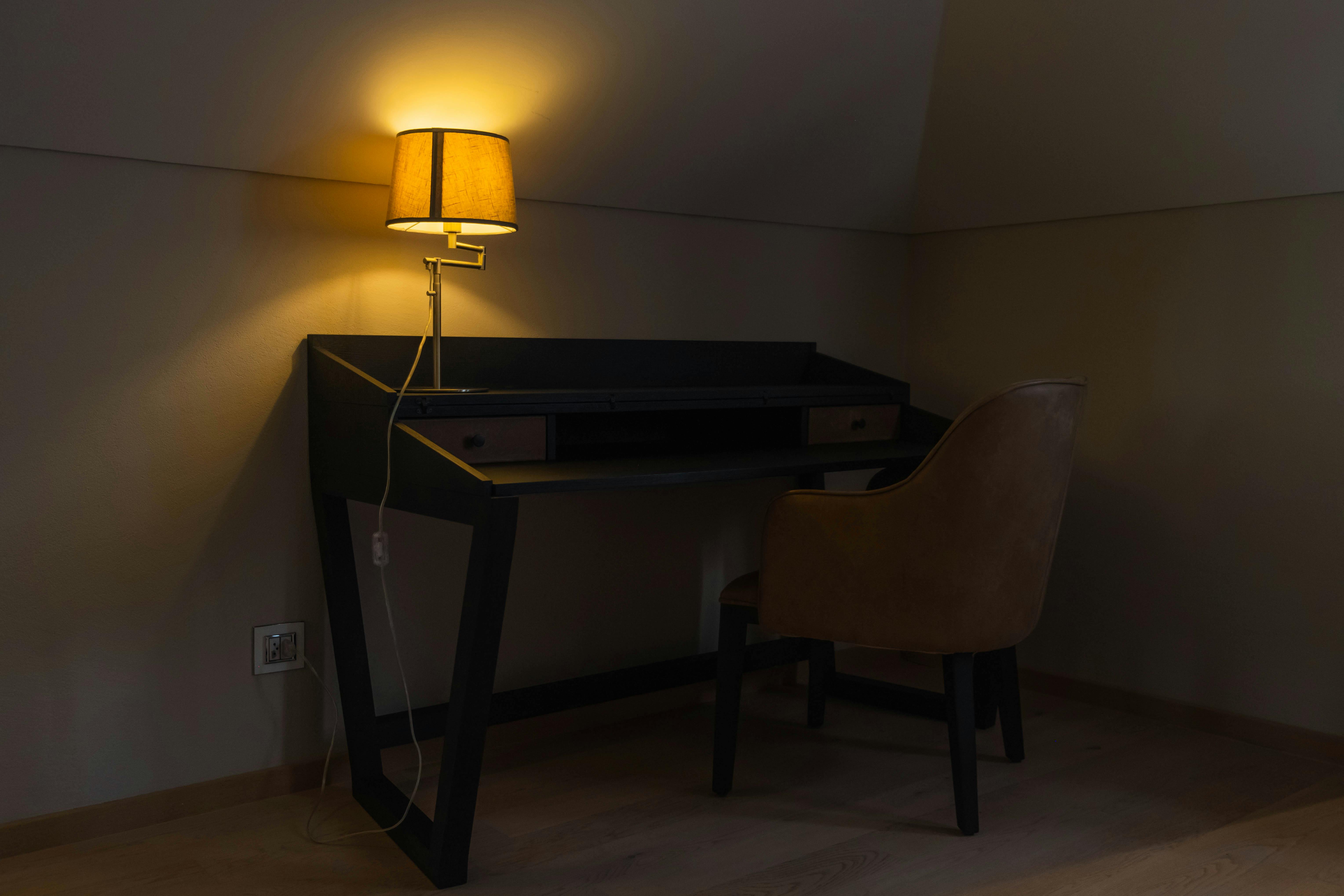 Detail einer Stehleuchte neben Sessel in einer Altbau-Ecke mit weichem, indirektem Licht