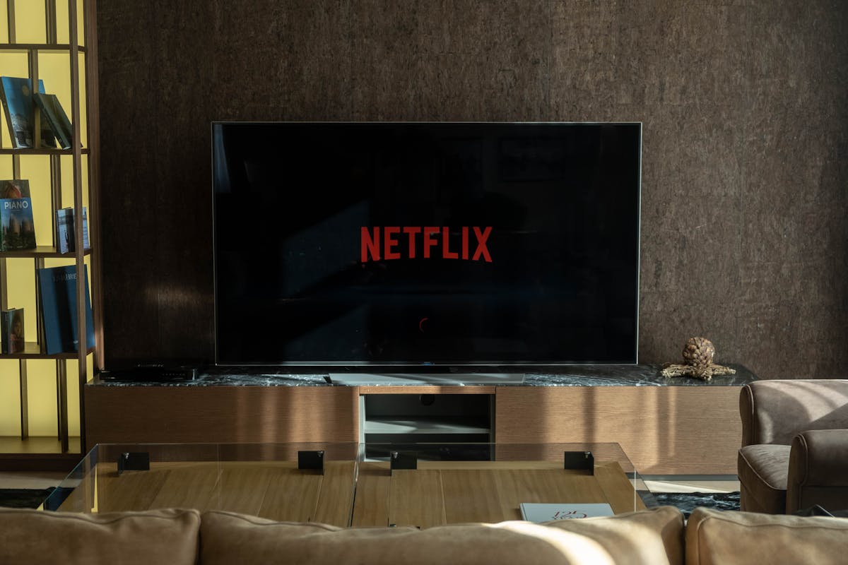Schermo TV che mostra l'interfaccia Netflix con profili e suggerimenti