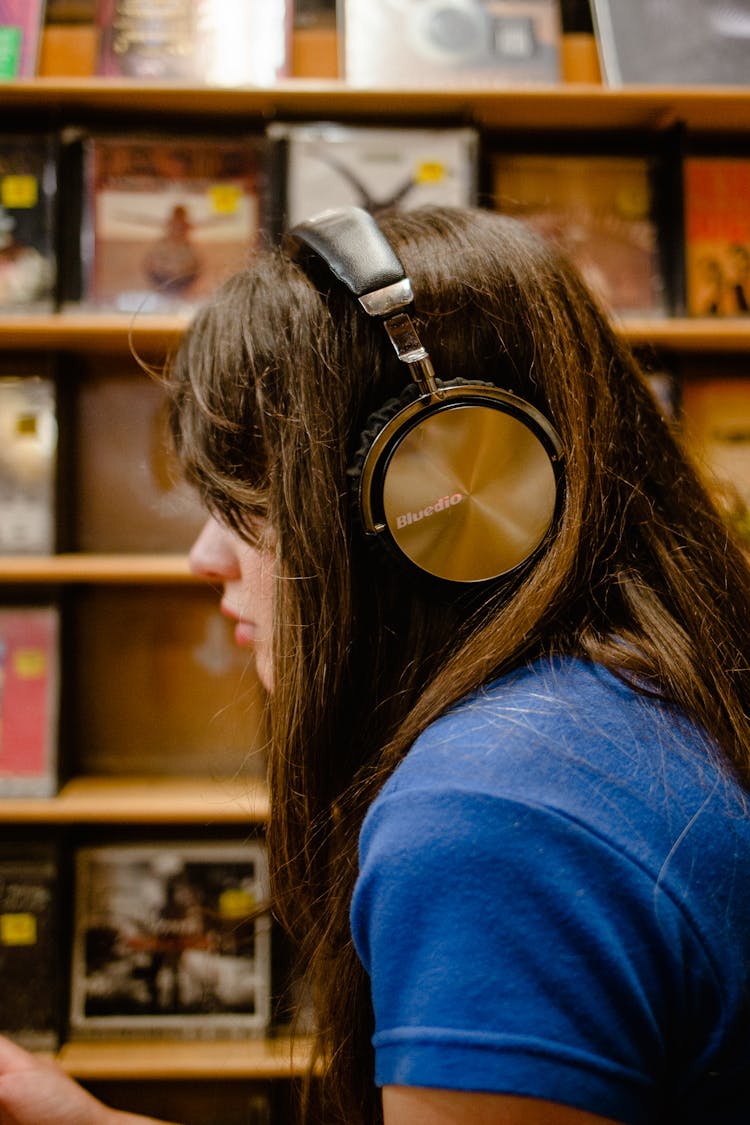 Woman In Blue Shirt Wearing Black Headphones