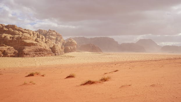 Explore the breathtaking red desert landscape of Wadi Rum, Jordan with towering sandstone formations.