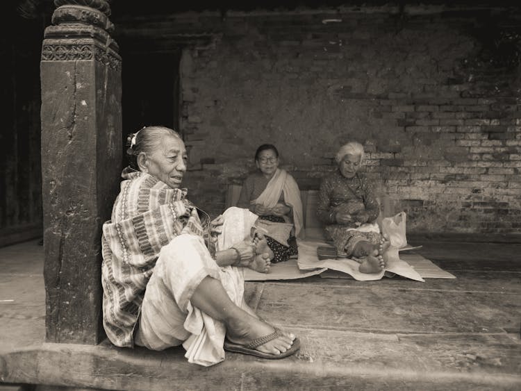 Elderly Women Sitting In Front Of A Temple 