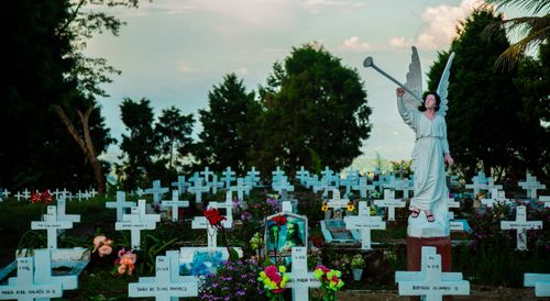 Free A serene cemetery in Samaná, Colombia featuring a prominent angel statue amidst gravestones. Stock Photo