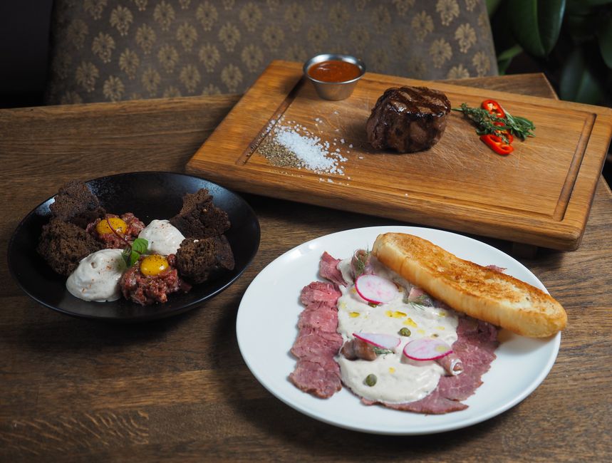 Carpaccio de carne cruda y embutidos variados en platos de servir