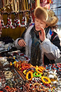 Asian woman selling vibrant jewelry at Beijing market. Lively display of necklaces, bracelets, and souvenirs.
