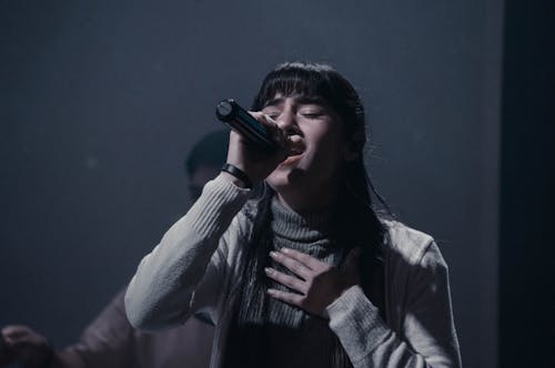A Woman in a Turtleneck Sweater Singing