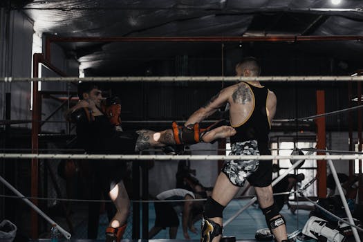 Two men engaged in a dynamic kickboxing sparring session in a gym ring.
