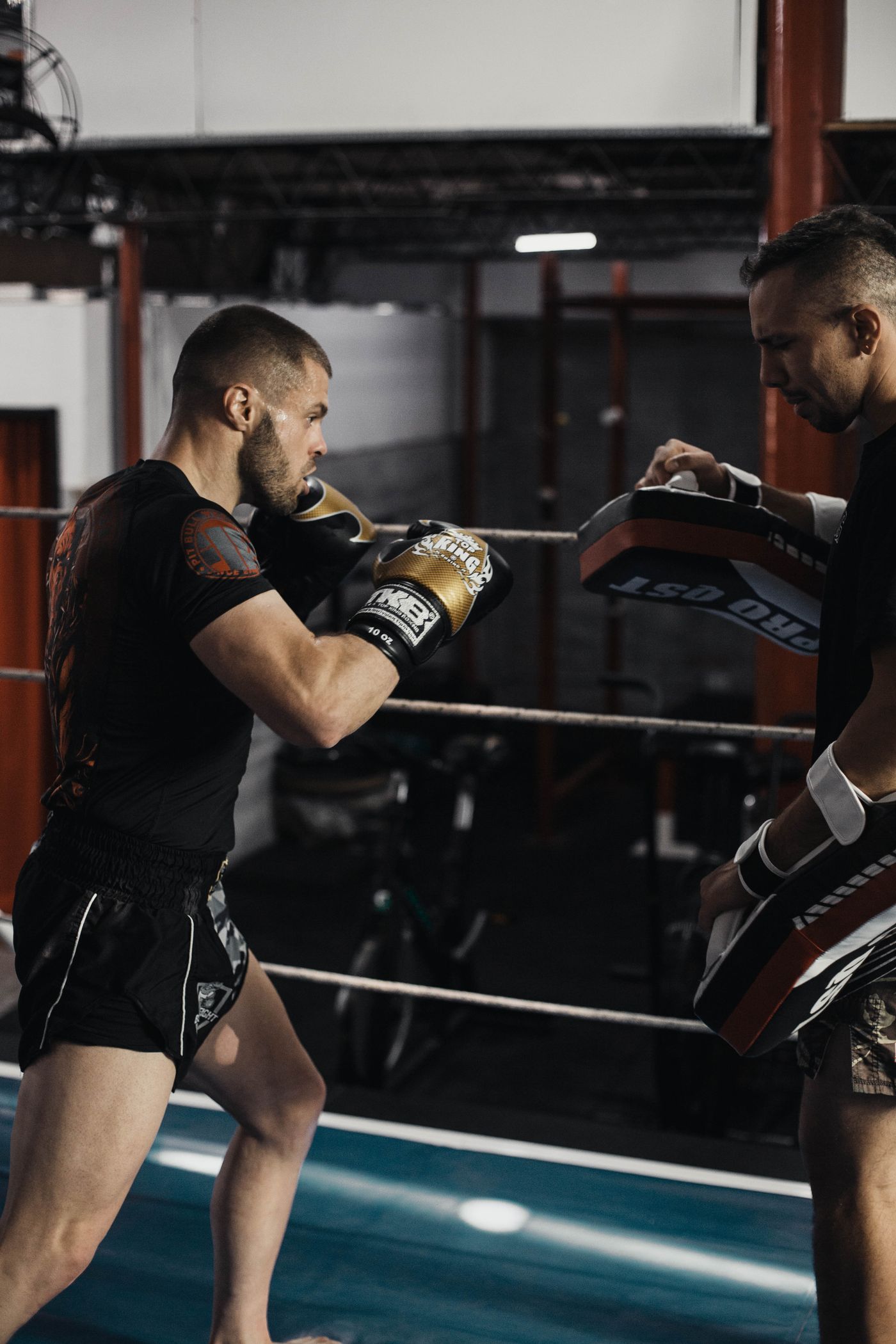 Kickboxer working combinations on pads with a coach.