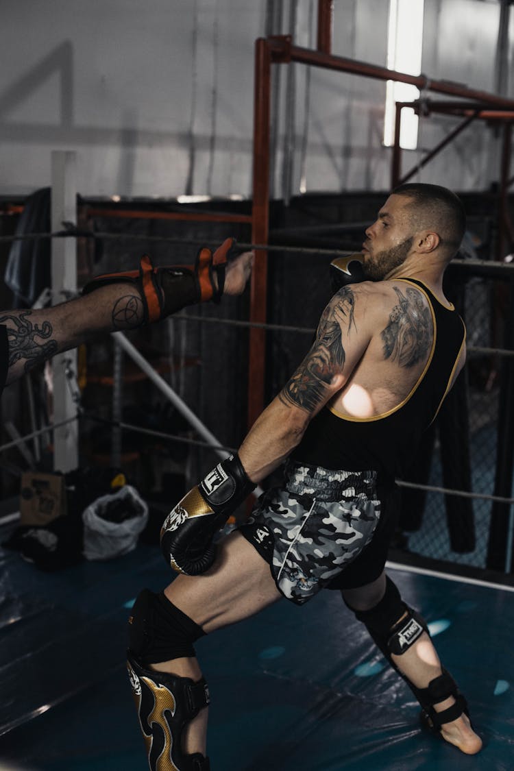 A Tattooed Kick Boxer Dodging A Kick