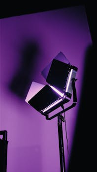 Purple-toned studio spotlight casting dramatic shadows on the wall.