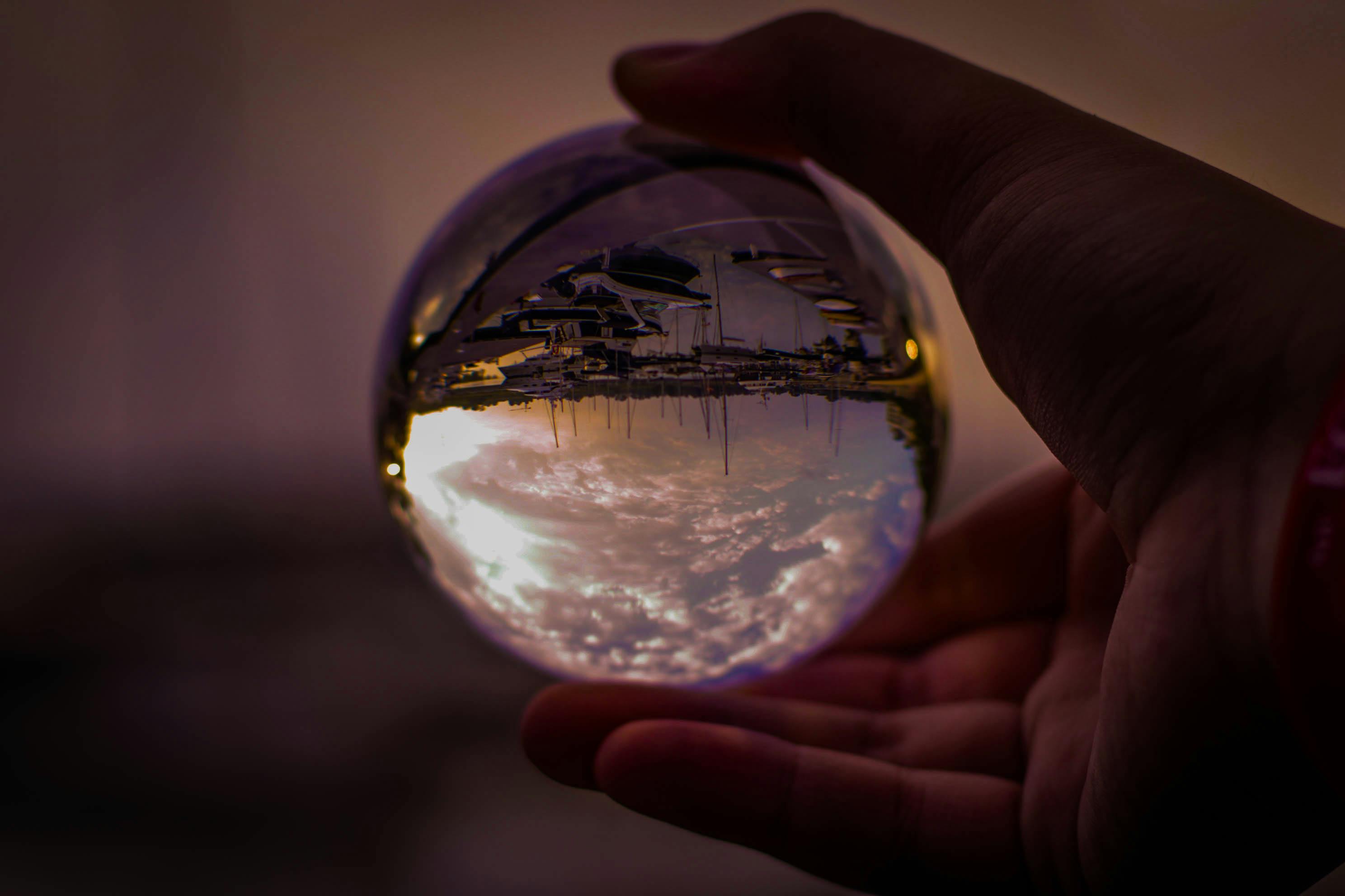 Selective Focus Photography of Person Holding Glass Ball