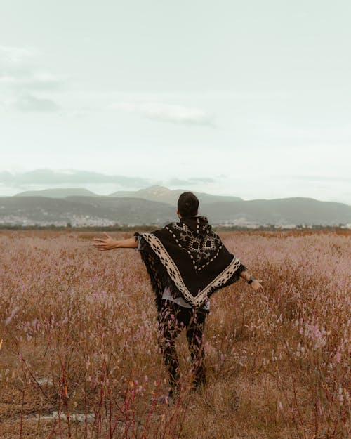 Free Man in Poncho on Meadow Stock Photo