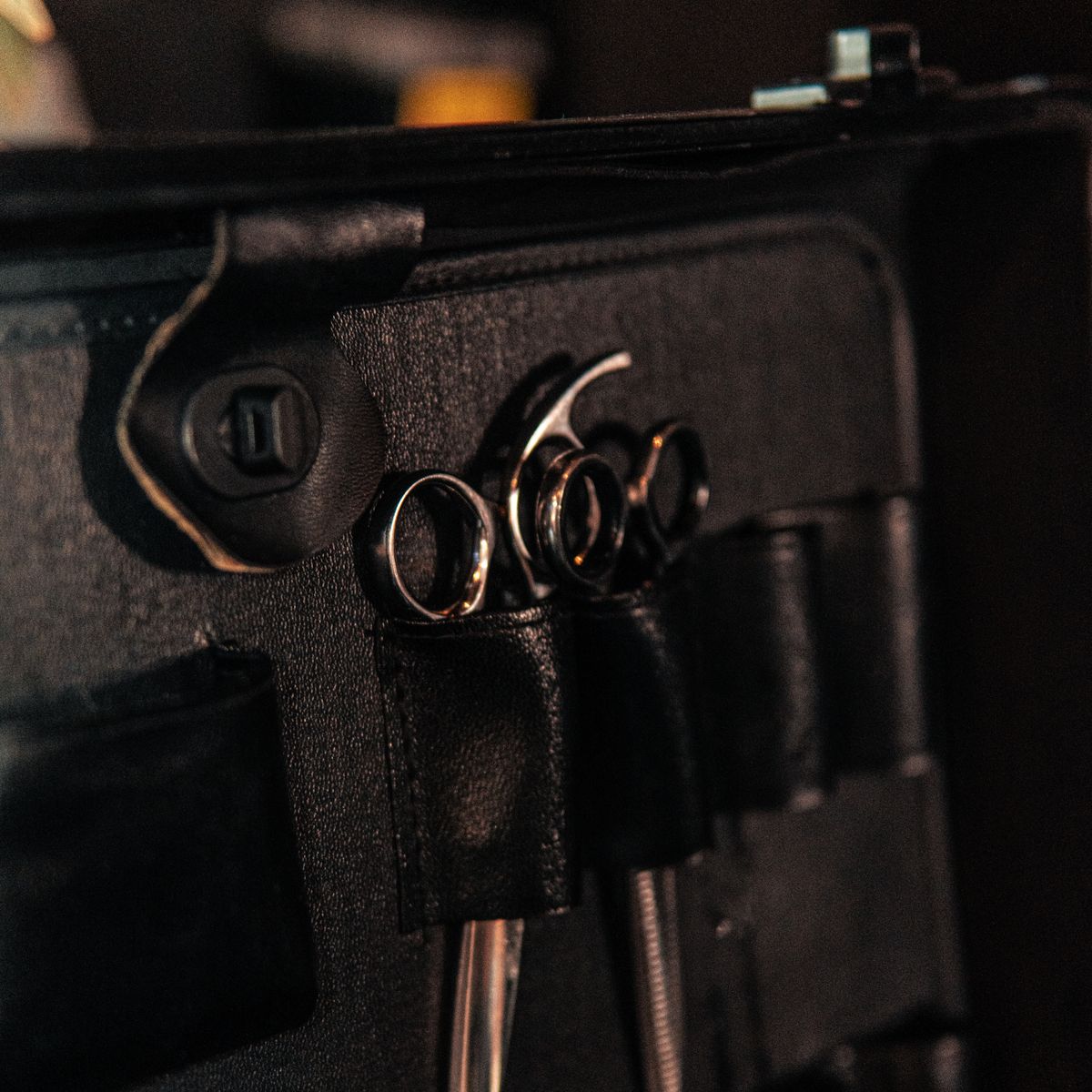 Close-up image of hairdressing scissors in a leather case, ideal for beauty industry use.