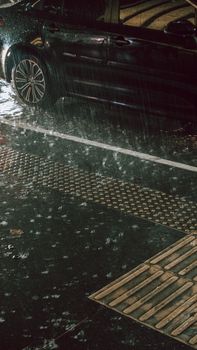 Car parked on a wet street at night during a rainstorm in São Paulo, Brazil.