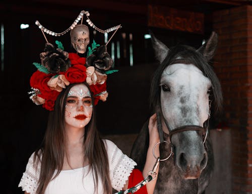 Woman with Face Paint Standing Beside a Horse