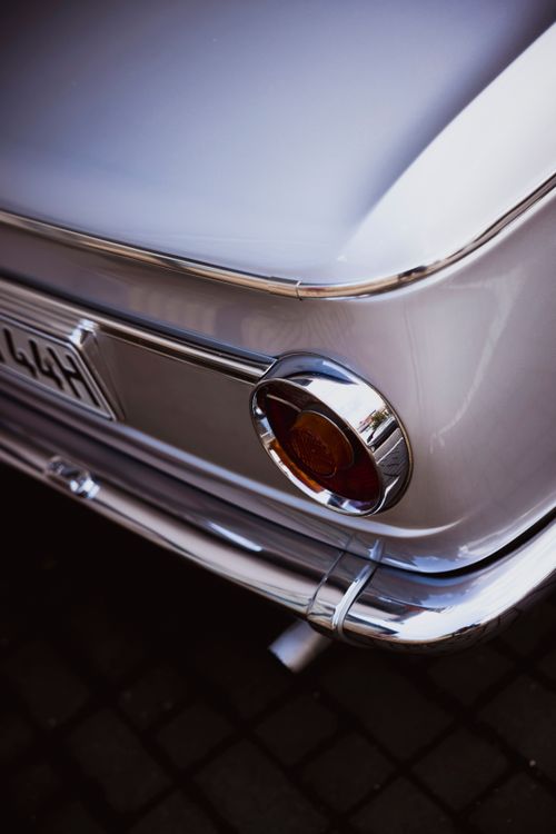 Free Close-up of a classic vintage car's rear featuring chrome details and retro tail light. Stock Photo