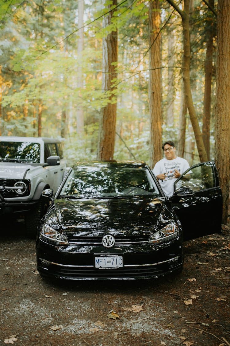 Man Standing Beside His Black Car