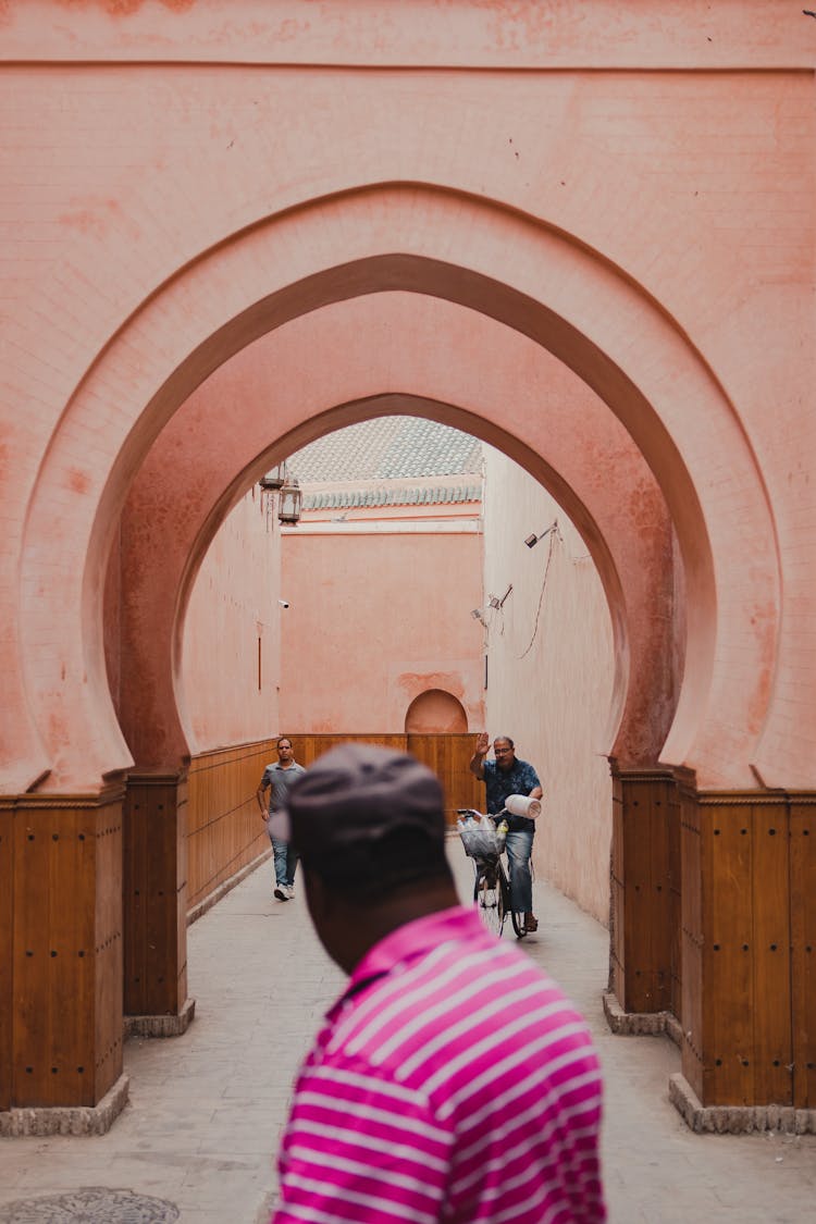 People Passing Through An Arched Passage