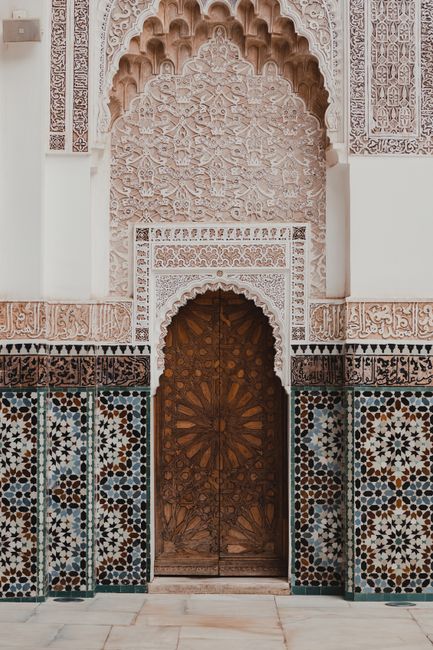 A beautifully decorated mosque entrance featuring intricate Islamic patterns and designs.
