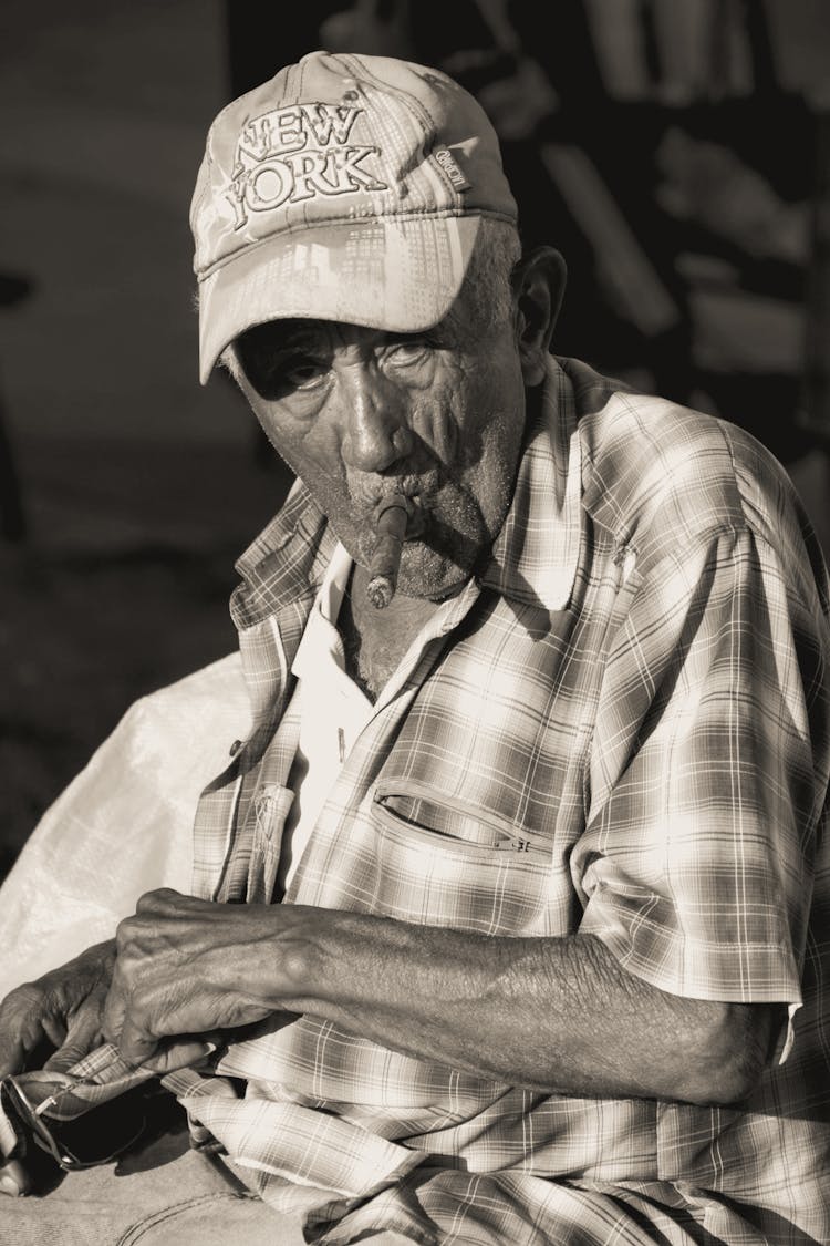 Monochrome Shot Of An Elderly Man Smoking Cigar