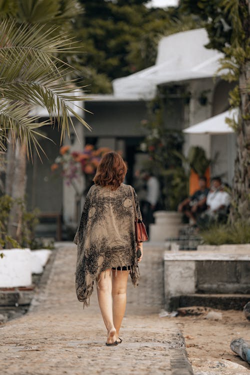 Back View of a Woman with Shawl Walking on a Footpath