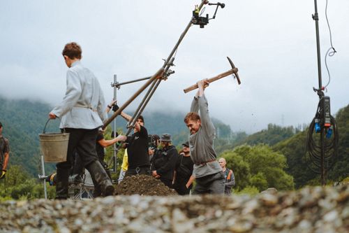 Free Film crew setting up a historical scene with actors outdoors in nature. Stock Photo