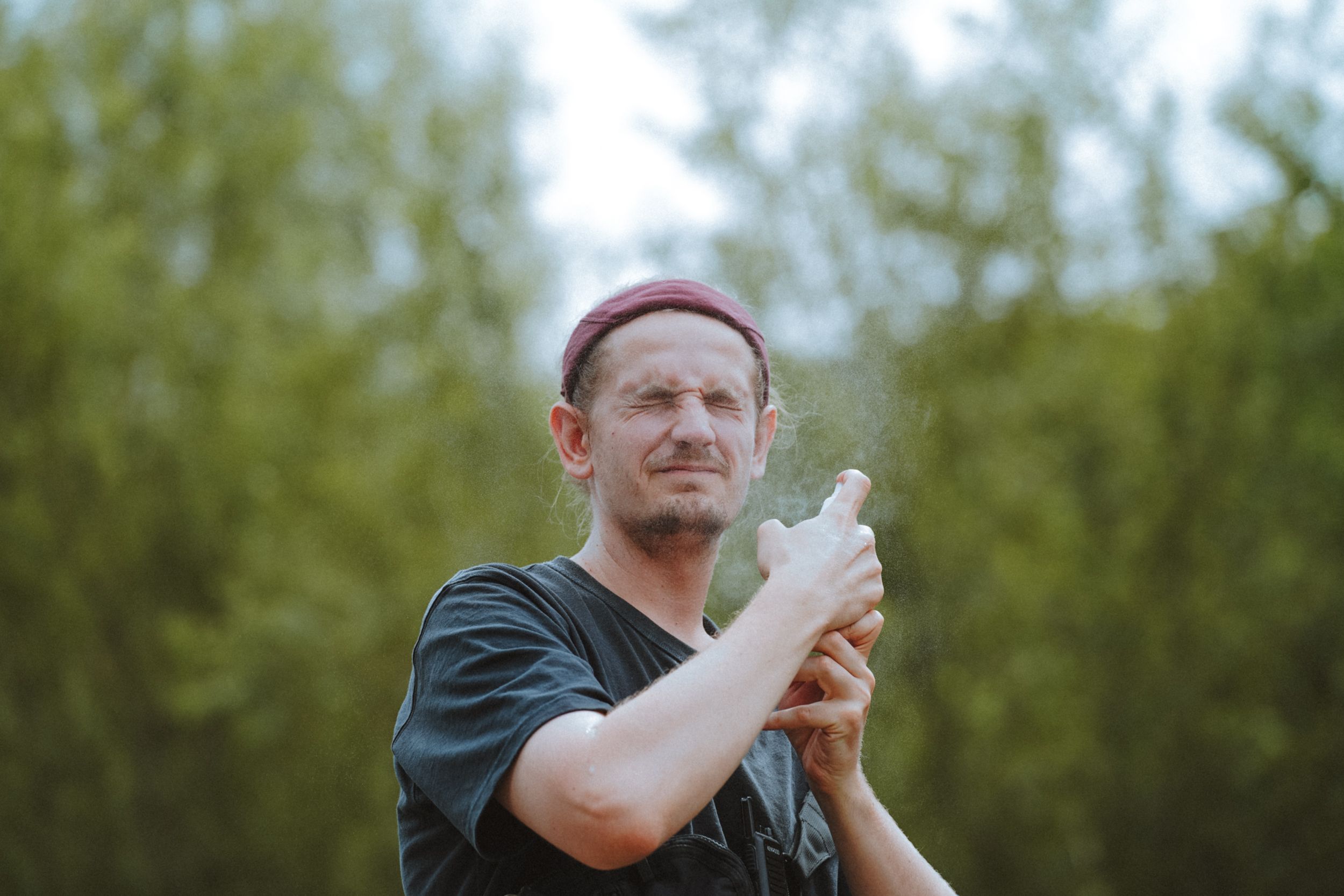 Man Spraying His Face Outdoors 