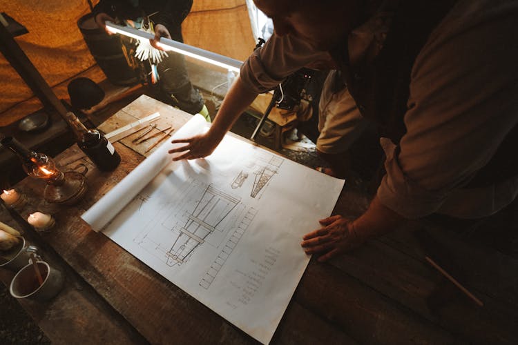 Men Looking At A Paper With An Architecture Construction Drawing