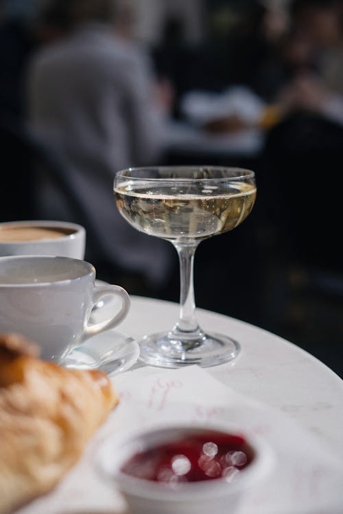 Glass of Wine and Food on a Table in a Cafe 