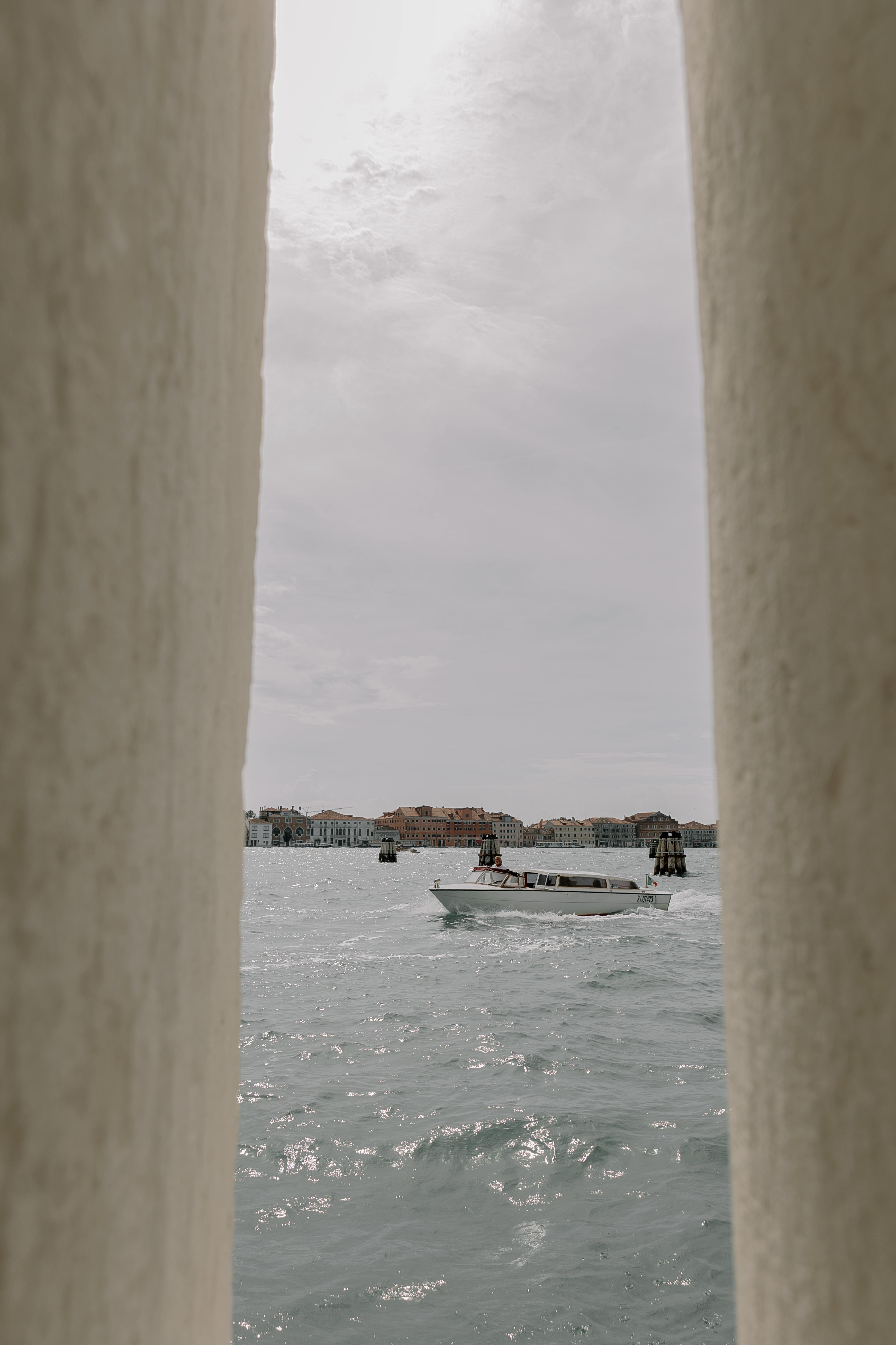 Boat in Sea Seen between Pillars · Free Stock Photo