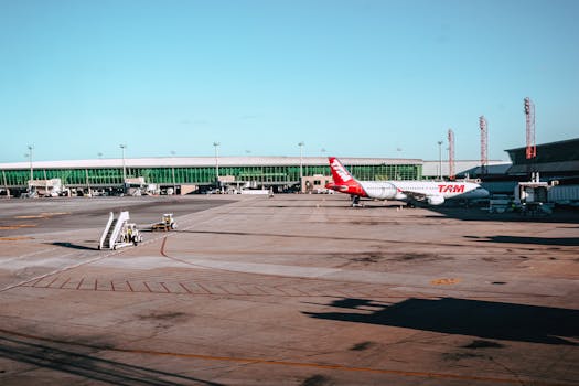 Wide view of a TAM airplane on the tarmac with a clear blue sky backdrop.