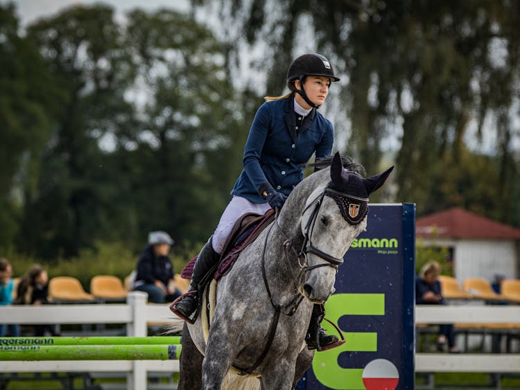 A Woman Riding A Horse In A Track