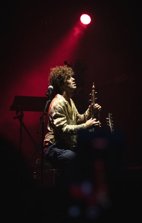 Man Playing a Musical Instrument on Stage 