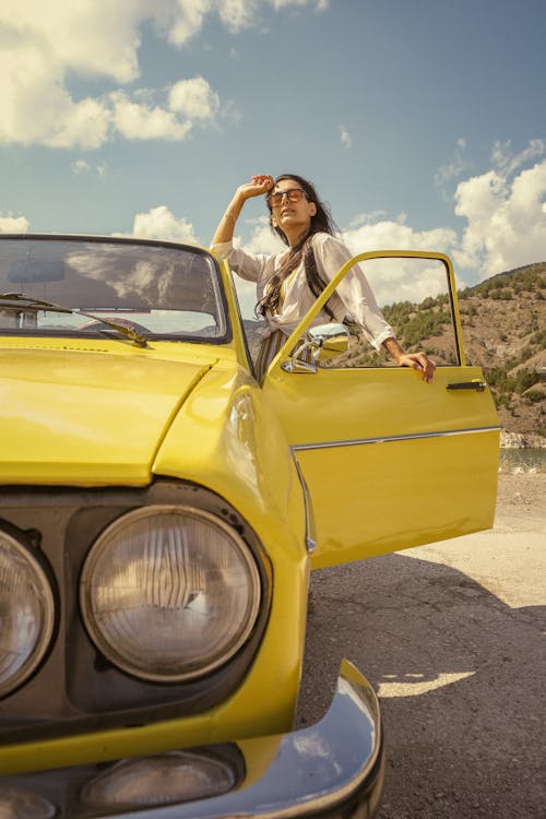 Woman Standing at Yellow Vintage Car